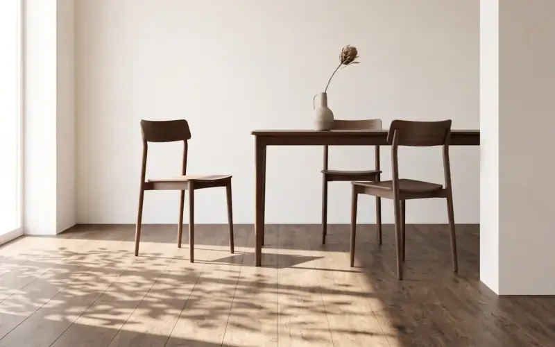 Dark oak plank floor in a bright dining area with two walnut chairs and a table by a window