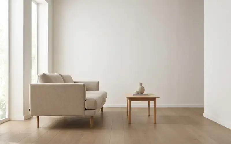 Natural oak plank flooring in a bright, minimal living room with a linen sofa and a low wood table