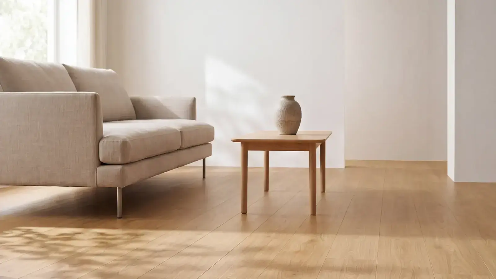 Natural oak plank flooring in a bright room with a linen sofa and a small wood side table