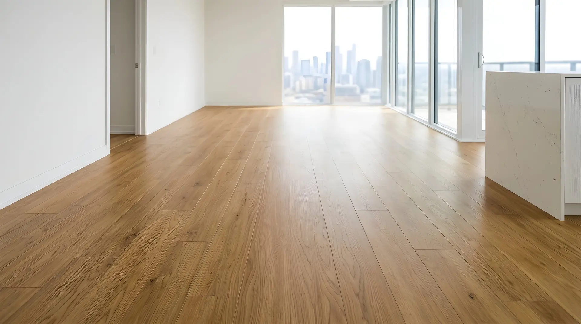 Golden oak flooring in a bright, freshly floored condo unit with a skyline view